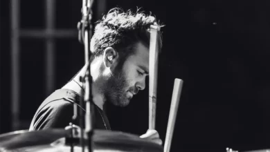 Grayscale photo of a man playing drums