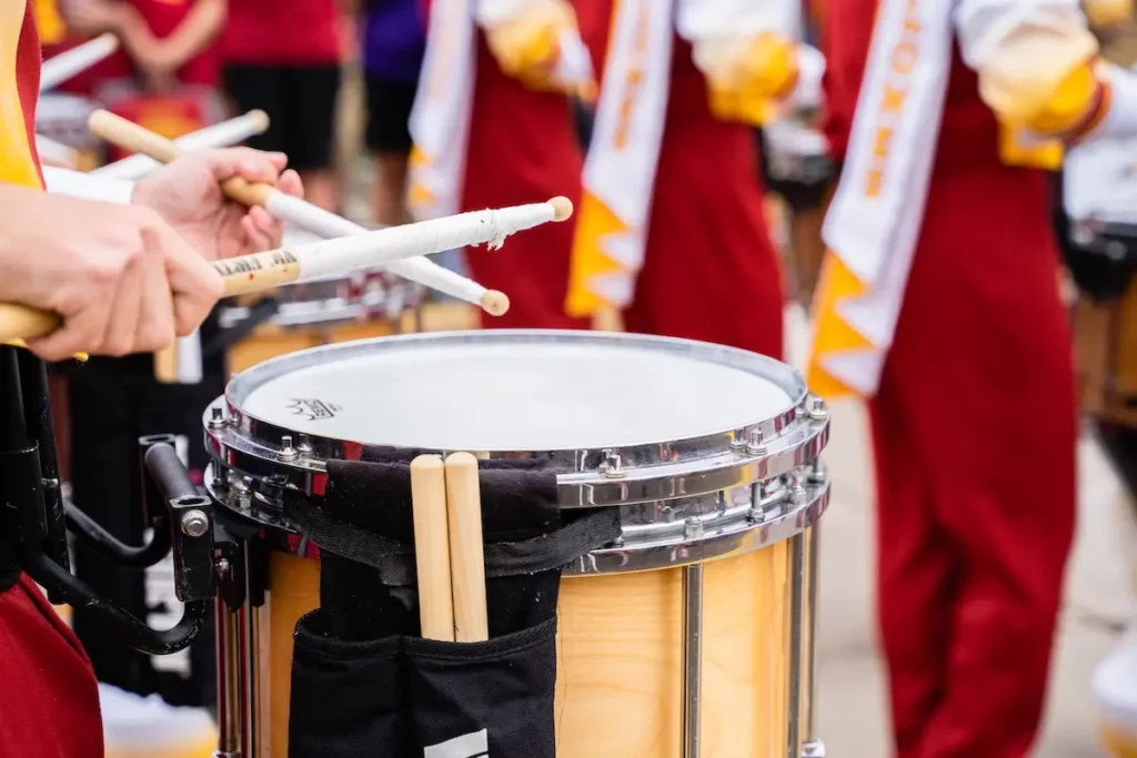 Marching snare drum player using traditional grip