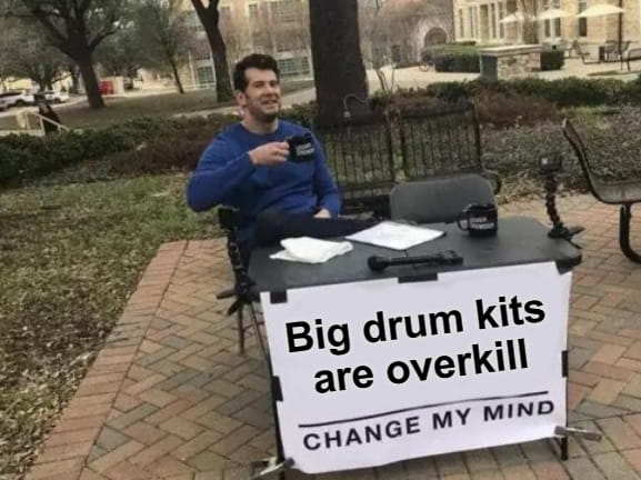 Steven Crowder change my mind meme, with the sign in front of the table reading "big drum kits are overkill, change my mind"