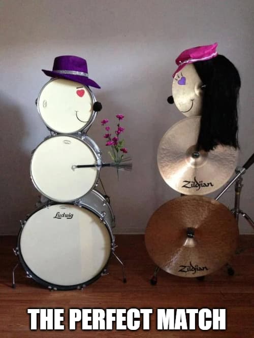A set of stacked drums and stacked cymbals that look like a man giving flowers to a woman